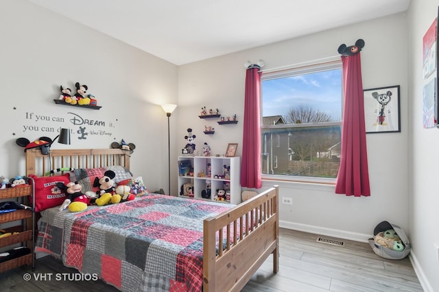 bedroom featuring visible vents, baseboards, and wood finished floors