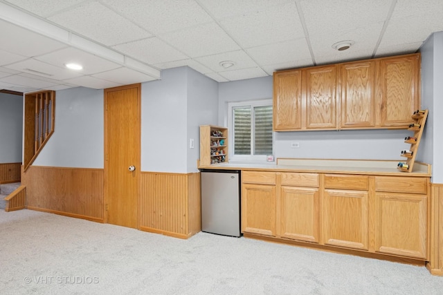 kitchen with refrigerator, wainscoting, and a paneled ceiling