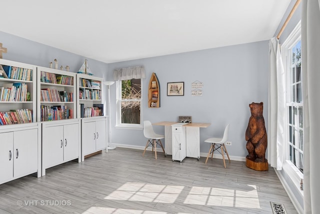 office area with baseboards, visible vents, and wood finished floors