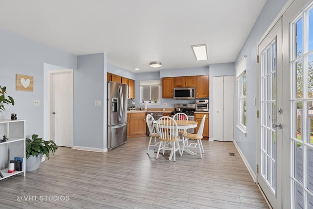dining room with baseboards and light wood-style floors