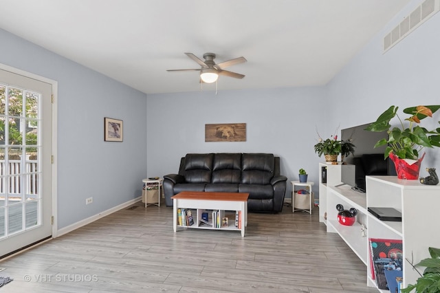 living area featuring visible vents, baseboards, ceiling fan, and wood finished floors