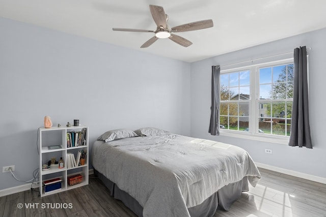 bedroom with baseboards, a ceiling fan, and wood finished floors