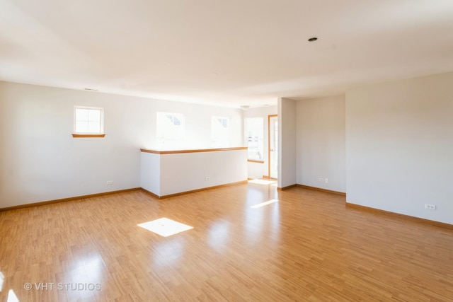 unfurnished room featuring baseboards and light wood-style flooring
