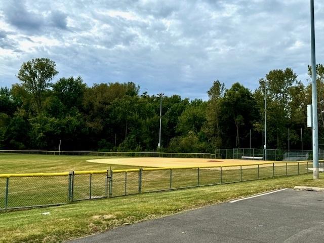 view of community featuring volleyball court, fence, and a yard