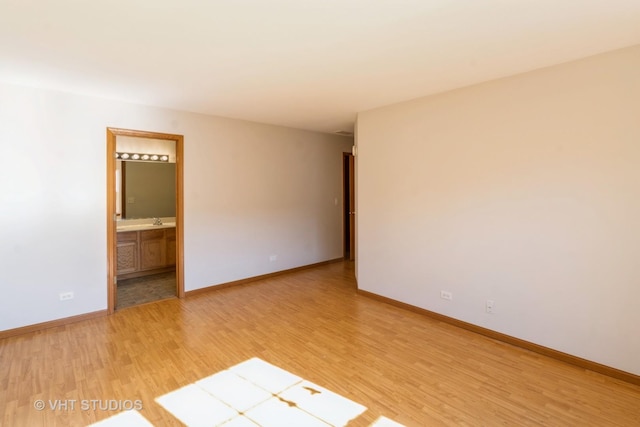 empty room with light wood-type flooring and baseboards
