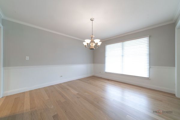 unfurnished room with light wood-type flooring, baseboards, an inviting chandelier, and ornamental molding