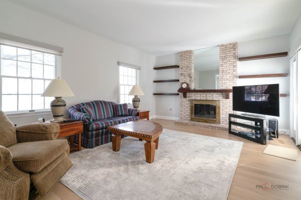living area with baseboards, wood finished floors, and a fireplace