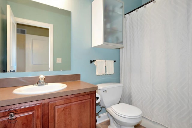 bathroom featuring toilet, a shower with curtain, vanity, and visible vents