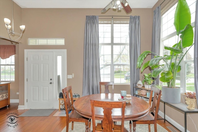 dining area featuring light wood finished floors, a wealth of natural light, and baseboards