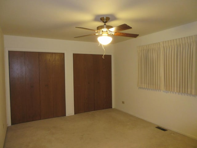 24541 S Wildwood Trl, Crete, IL 60417 - unfurnished bedroom with a ceiling fan, multiple closets, visible vents, and carpet