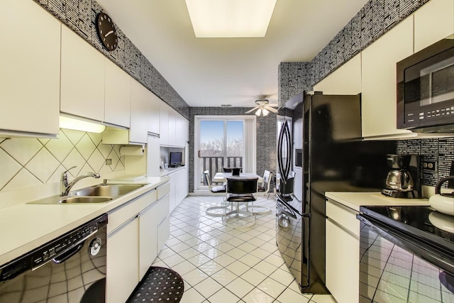 kitchen featuring light countertops, a sink, black appliances, and tasteful backsplash