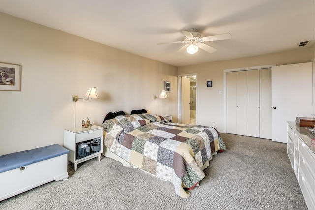 bedroom with a closet, carpet floors, visible vents, and a ceiling fan