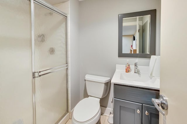 bathroom featuring a stall shower, baseboards, vanity, and toilet