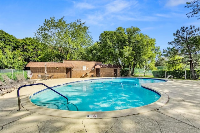 pool featuring fence and a patio
