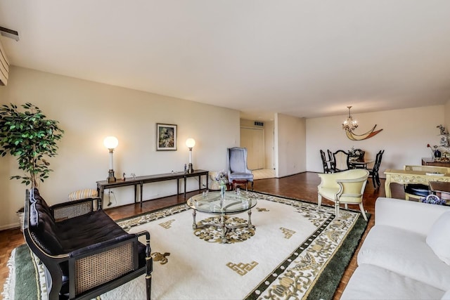 living area featuring wood finished floors, visible vents, and a notable chandelier