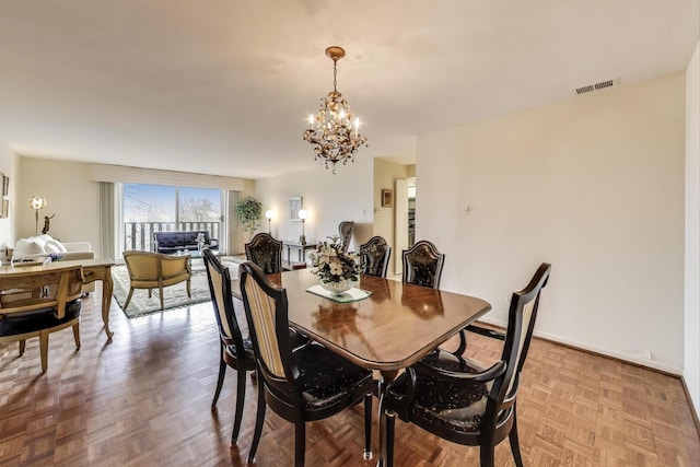 dining area featuring baseboards, visible vents, and a notable chandelier