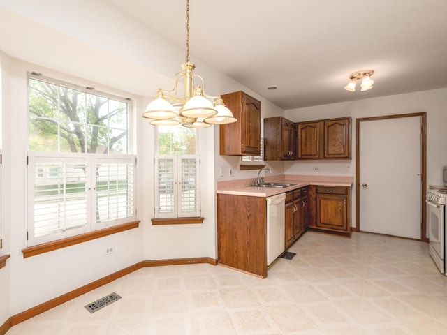 kitchen featuring brown cabinets, white appliances, light countertops, a chandelier, and visible vents