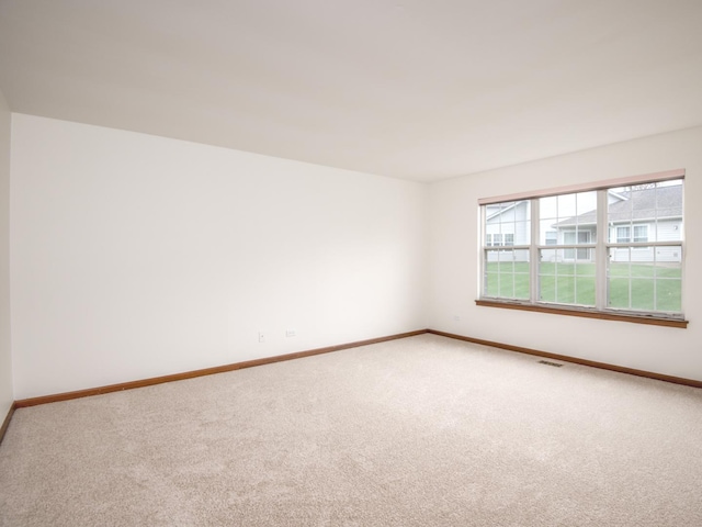 empty room with baseboards, carpet flooring, and visible vents