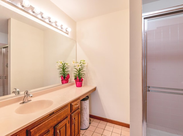 full bath featuring vanity, baseboards, tile patterned flooring, and a stall shower