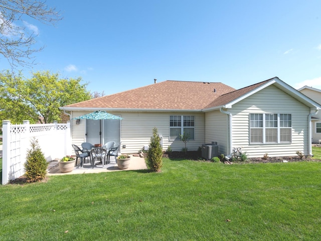 rear view of property featuring central air condition unit, fence, a yard, and a patio area