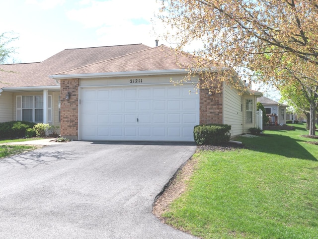 view of front of property with a garage, a front yard, driveway, and brick siding
