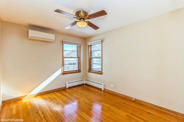 spare room featuring light wood-style flooring, a wall unit AC, baseboards, a ceiling fan, and baseboard heating