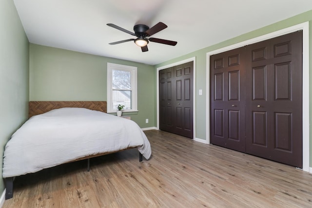 1926 County Road 2800 E, Minonk, IL 61760 - bedroom featuring baseboards, multiple closets, wood finished floors, and a ceiling fan