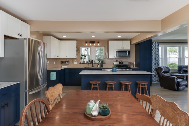 1926 County Road 2800 E, Minonk, IL 61760 - kitchen featuring a breakfast bar, stainless steel appliances, light countertops, white cabinetry, and a kitchen island