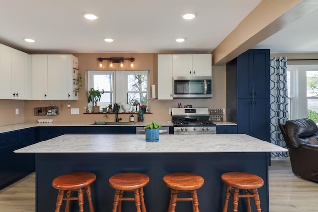 1926 County Road 2800 E, Minonk, IL 61760 - kitchen with a kitchen breakfast bar, light wood-style flooring, stainless steel appliances, and a sink