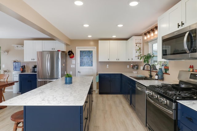 1926 County Road 2800 E, Minonk, IL 61760 - kitchen featuring stainless steel appliances, blue cabinets, a sink, a center island, and light wood-style flooring