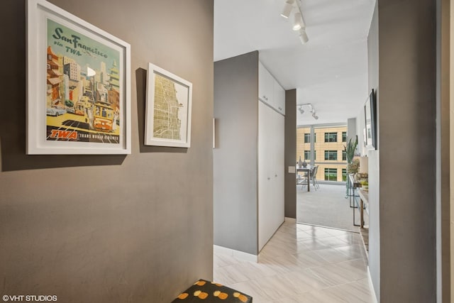 corridor with floor to ceiling windows and rail lighting
