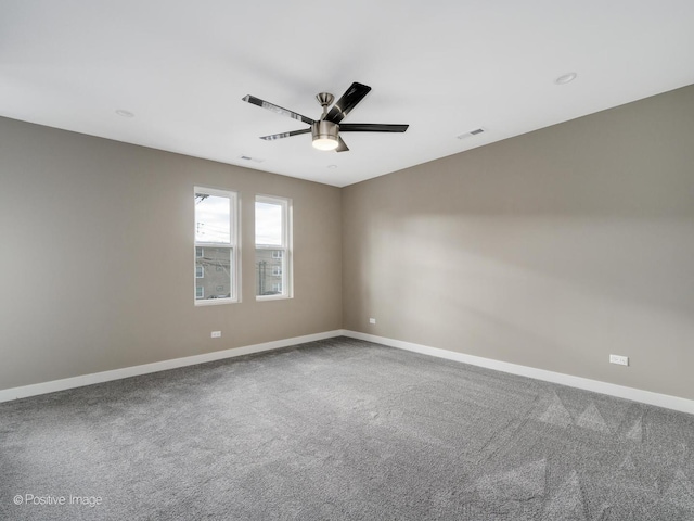empty room featuring carpet, visible vents, a ceiling fan, and baseboards