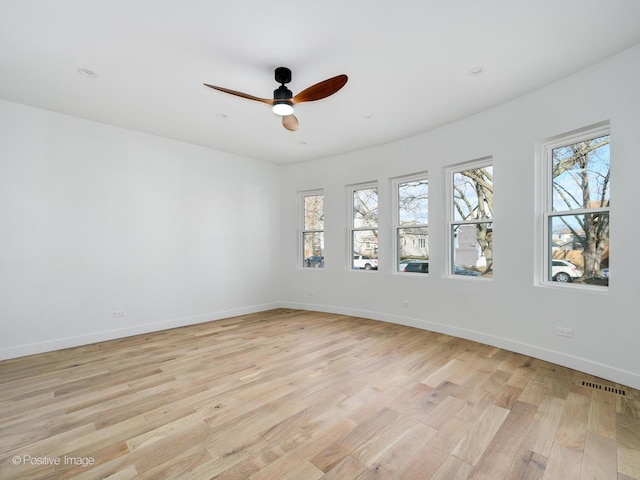 empty room with plenty of natural light, visible vents, baseboards, and light wood-type flooring