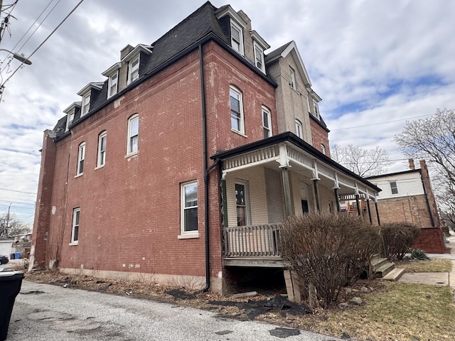 645 E 113th St, Chicago, IL 60628 - view of home's exterior with brick siding, roof with shingles, mansard roof, and covered porch