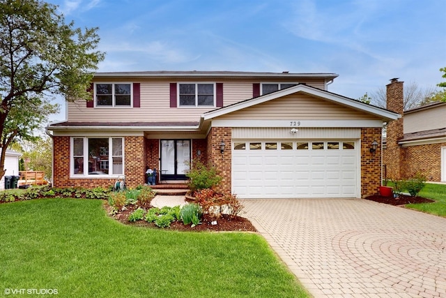 traditional home with a front yard, brick siding, a garage, and decorative driveway