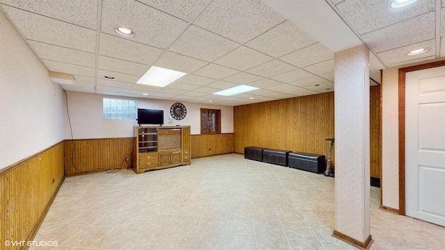 interior space with a paneled ceiling, wooden walls, recessed lighting, and a wainscoted wall
