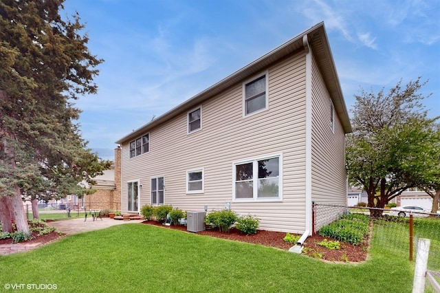 rear view of property with a lawn, central air condition unit, a patio, and fence