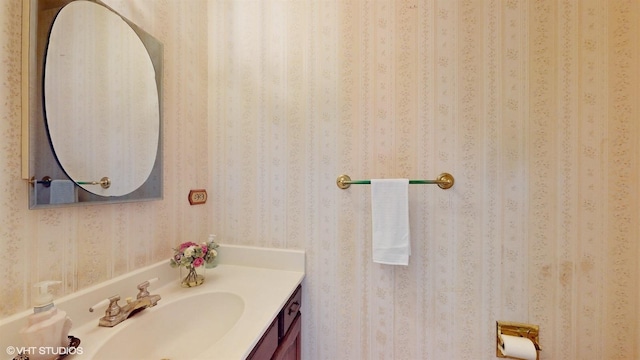 bathroom featuring wallpapered walls and vanity