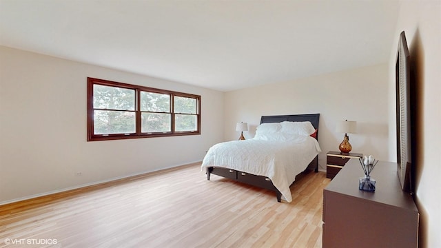 bedroom featuring light wood finished floors and baseboards