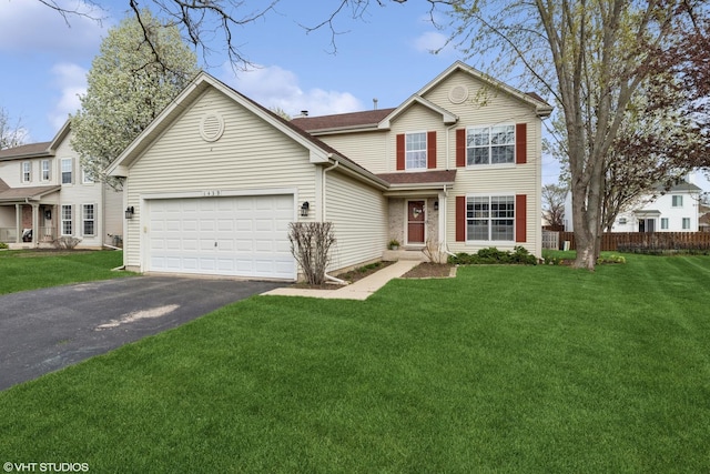 traditional home with fence, an attached garage, driveway, and a front yard