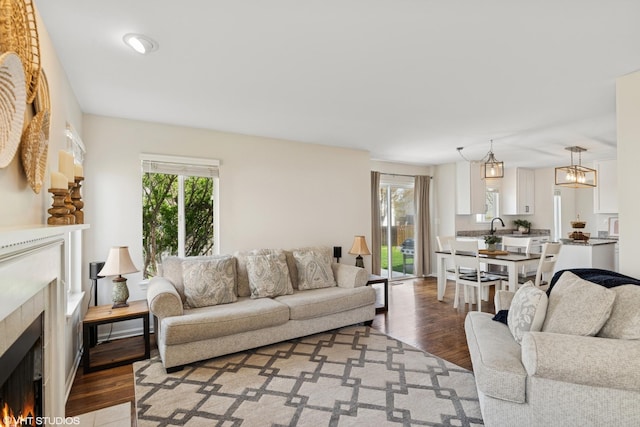 living room with a tiled fireplace and light wood-style floors