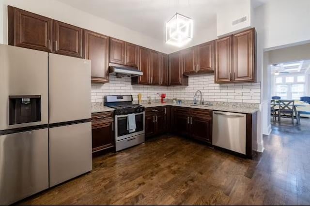 kitchen featuring a sink, stainless steel appliances, under cabinet range hood, dark wood-type flooring, and visible vents