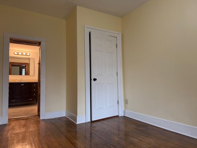 310 Elk St, Galena, IL 61036 - unfurnished bedroom with baseboards, wood finished floors, and a sink