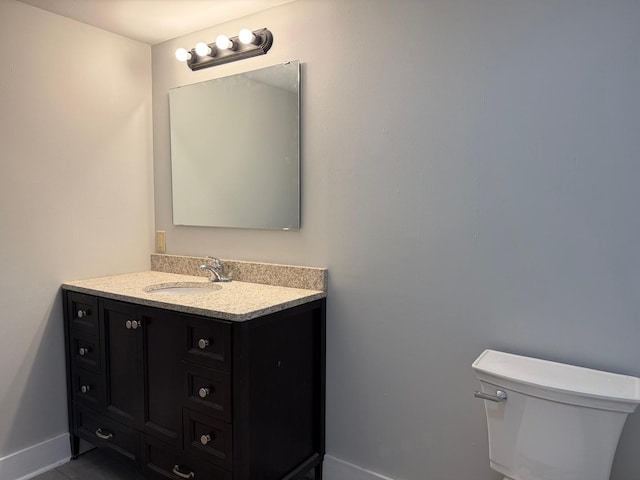 310 Elk St, Galena, IL 61036 - half bath featuring baseboards, vanity, tile patterned flooring, and toilet
