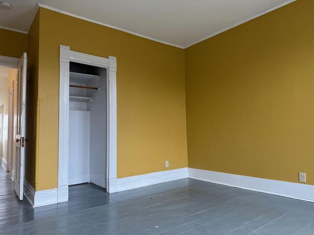 310 Elk St, Galena, IL 61036 - unfurnished bedroom with baseboards, dark wood-type flooring, a closet, and crown molding