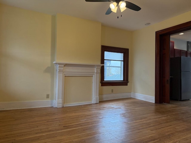 310 Elk St, Galena, IL 61036 - unfurnished living room with baseboards, a ceiling fan, and wood finished floors