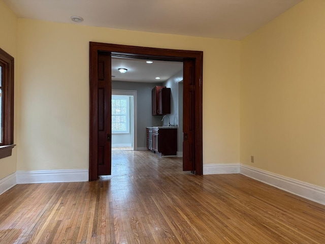 310 Elk St, Galena, IL 61036 - empty room with wood finished floors, baseboards, and a sink