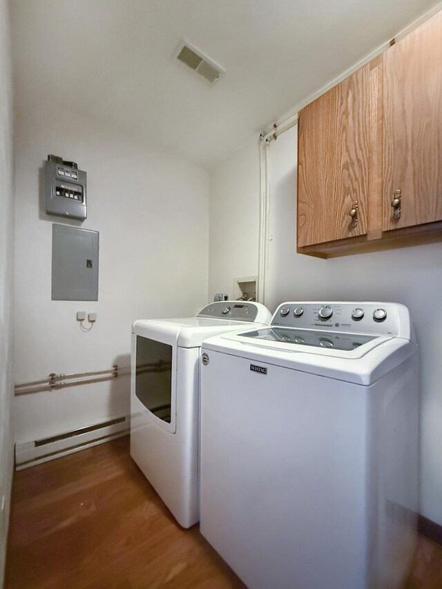 washroom featuring electric panel, light wood-style flooring, visible vents, cabinet space, and washer and dryer