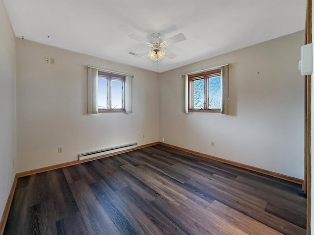 empty room with dark wood finished floors, visible vents, baseboards, baseboard heating, and a ceiling fan
