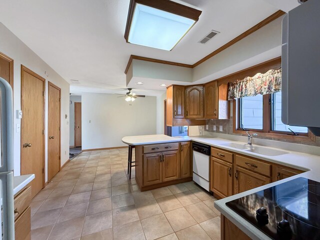 kitchen with a kitchen breakfast bar, a sink, dishwasher, a peninsula, and visible vents